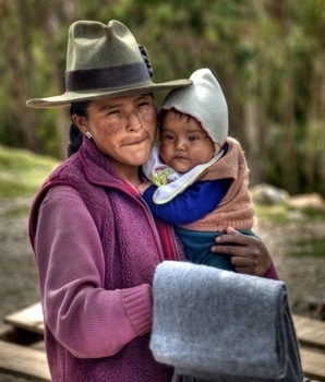 Eine Quechua-Frau hält ihr Kind im Arm.